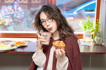 Oriental women eating a lot at the Meiyan hot dog fast food restaurant