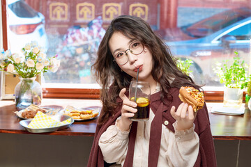 Oriental women eating a lot at the Meiyan hot dog fast food restaurant
