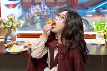 Oriental women eating a lot at the Meiyan hot dog fast food restaurant