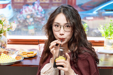 Oriental women eating a lot at the Meiyan hot dog fast food restaurant