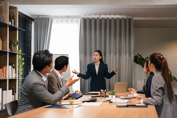 Young business woman executive ceo leader discussing project management planning strategy working with diverse colleagues company team at office corporate board group meeting.