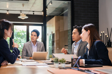 Successful team. Handsome and cheerful mature business man in formal wear discussing business plan  with colleagues while working together in the office.