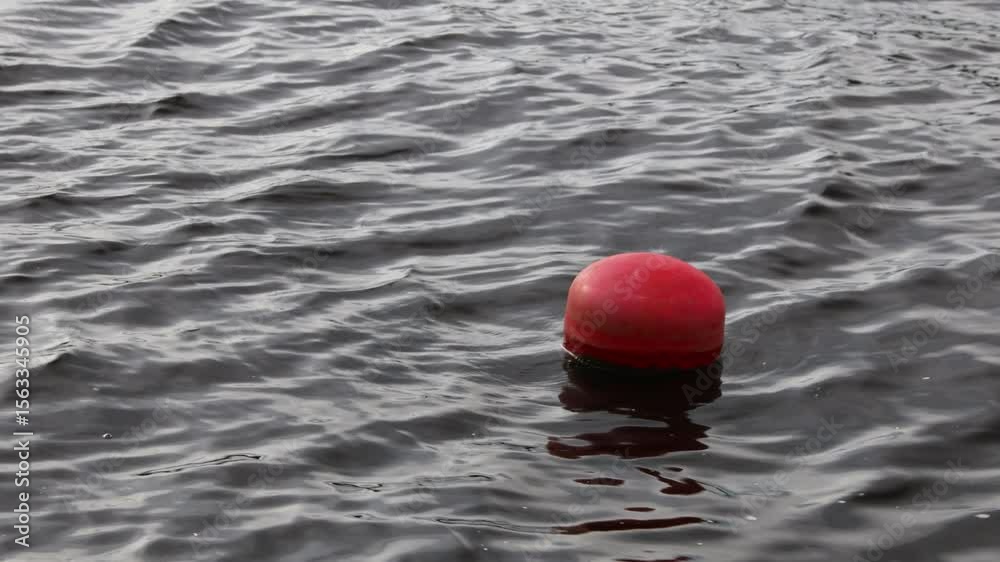 Poster a single red buoy floats on the surface of calm water