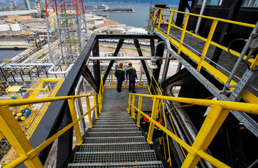 refinery and workers coming down the stairs work safety image