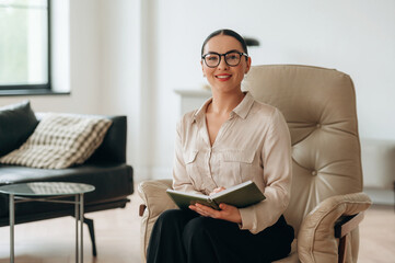 Smiling, positive facial expression. Woman in formal clothes is in the modern big room