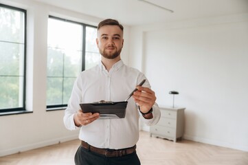 Pen in hand, sign the deal, buy new home. Real estate agent is in the new room