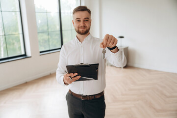 Keys for the new home in hand. Real estate agent is in the new room