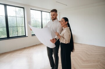 Reading the plan of room. Man and woman are indoors, conception of business