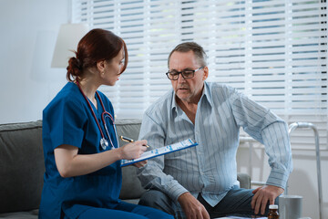 Female doctor consulting senior old patient filling form at consultation, talking to senior old...
