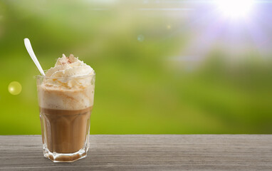 Refreshing iced coffee beverage topped with whipped cream and caramel drizzle, served in a clear...
