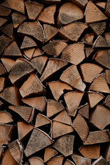 Stacked firewood arranged in neat rows showing cut surfaces and natural wood texture, closeup view...
