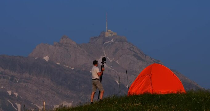 Capturing nature's beauty while camping near the majestic mountain summit during golden hour