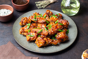 Chicken wings in teriyaki sauce with sesame and onion. Asian food.