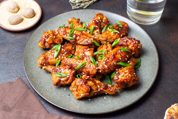 Chicken wings in teriyaki sauce with sesame and onion. Asian food.