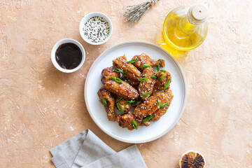 Chicken wings in teriyaki sauce with sesame and onion. Asian food.