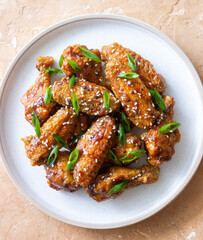 Chicken wings in teriyaki sauce with sesame and onion. Asian food.