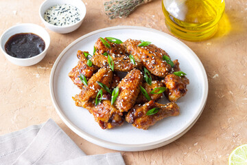 Chicken wings in teriyaki sauce with sesame and onion. Asian food.