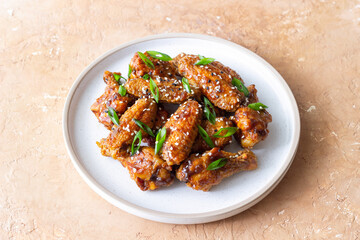 Chicken wings in teriyaki sauce with sesame and onion. Asian food.