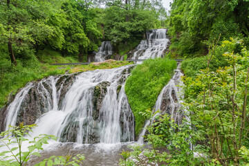 Cascades of the Dzhurynskyi waterfall in spring overcast day, Ukraine