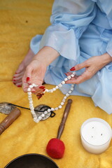 Calm person holds prayer beads. This image is used for meditation, mindfulness, or spiritual practice context.