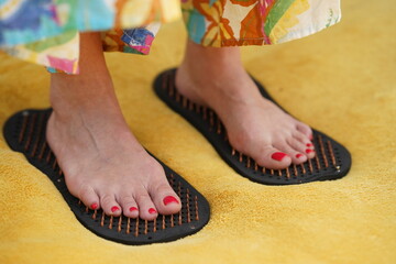 Female feet standing on acupressure insoles. Image suitable for wellness, health, and relaxation concepts.