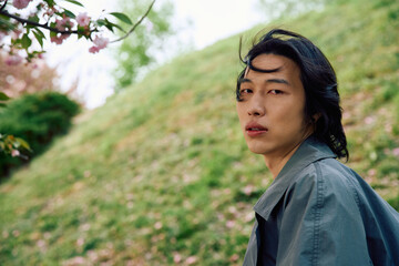 Stylish young man enjoying a serene moment in a beautiful park setting