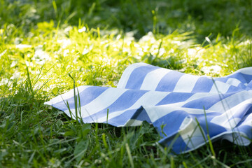 Blue towel, tablecloth on green grass empty food advertisement space background, backdrop.