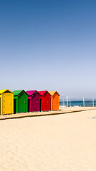 Vibrant cabins line on quiet sandy and sunny beach in Spain. For travel, summer, or vacation...