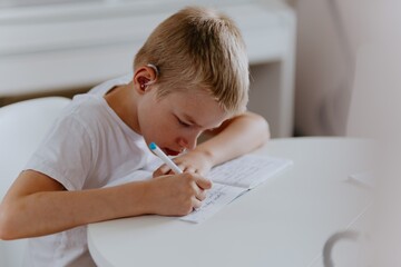 Young mother helps her hard-of-hearing son with schoolwork at home. A natural, heartfelt moment of...