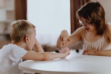 Young mother helps her hard-of-hearing son with schoolwork at home. A natural, heartfelt moment of...
