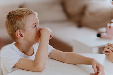 Young mother helps her hard-of-hearing son with schoolwork at home. A natural, heartfelt moment of...