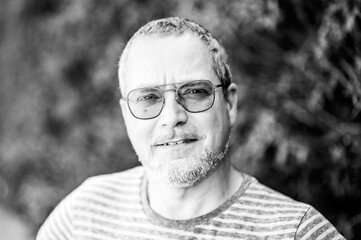 Portrait of a 49 yo man with glasses and a beard against a green background in Ternat, Flemish Brabant, Belgium