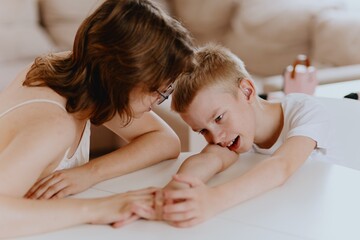 Young mother helps her hard-of-hearing son with schoolwork at home. A natural, heartfelt moment of...