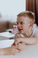 Young mother helps her hard-of-hearing son with schoolwork at home. A natural, heartfelt moment of...