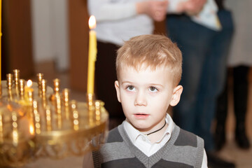 Young boy observes candle lighting ceremony in a church during a quiet moment of reflection