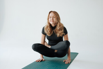 Mature woman practicing yoga pose on mat in studio, balance and strength training for healthy...