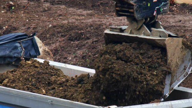 Heavy machinery transports compost for landscaping project in rural area