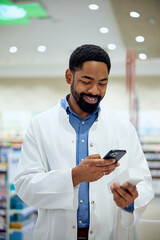 Pharmacist Using Smartphone While Smiling in Modern Pharmacy Store