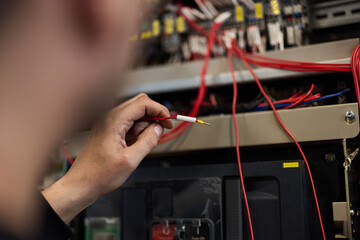 Close-Up of Technician Working With Wiring in Electrical Panel