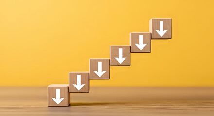 Downward trend depicted by wooden blocks ascending in steps, each featuring a white arrow pointing down on a vibrant yellow background.
