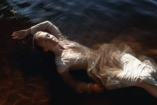 woman drifts gracefully in tranquil water, wearing a light-colored flowing dress. soft glow of sunset casts warm reflections while her peaceful expression reveals a moment of calm