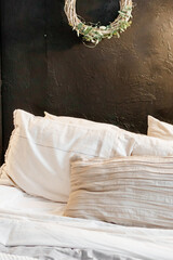 Decorations with garlands and a Christmas wreath. Cozy atmosphere of a home holiday, loft-style interior design. A wreath in close-up on a dark wall.