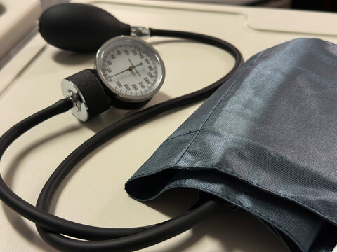 Manual Blood Pressure Cuff and Gauge on Hospital Bedside Table, Vital Signs Monitoring Equipment in Clinical Setting Representing Hypertension Screening and Patient Assessment