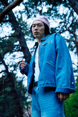 Stylish young man in denim outfit enjoying nature in a serene park setting