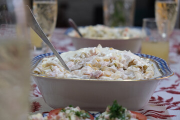 An exquisite salad in a beautiful plate decorates a festive table. The concept of a celebration, feast, family dinner, party or healthy eating