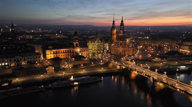 Dresden's historic Old Town at night, with Elbe River reflecting city lights. Dresren, Saxony, Germany. Aerial View.