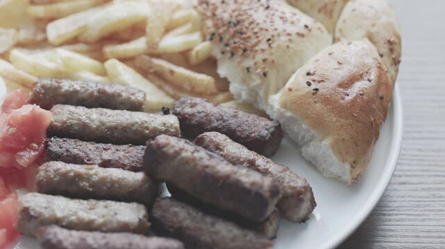 A balkan traditional meatball dish cevapi, cevapcici on wooden table in close-up