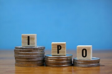 stock market and investment concept. ipo writing on wooden block and stack of coins isolated on...