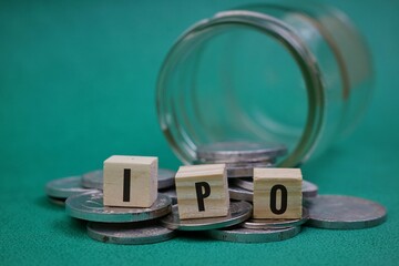stock market and investment concept. ipo writing on wooden block and stack of coins isolated on...