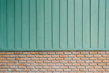 Green background. Textured Wooden Wall Above Light Brick Base with Green Paint for Creative...